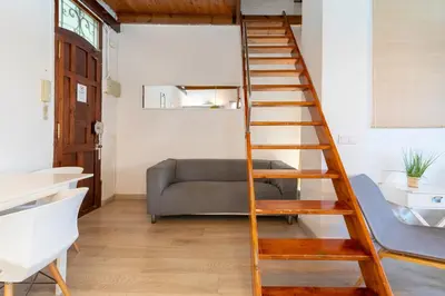 a spiral staircase in a living room with a couch at Barón Suites Ruzafa in Valencia