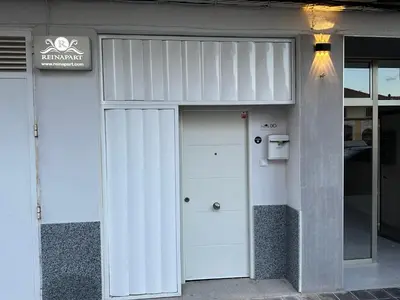 a building with a white door and a sign on it at Reinapart Valencia Beach in Valencia