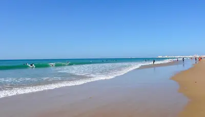 a group of people playing in the water at the beach at Reinapart Valencia Beach in Valencia