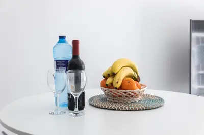 a basket of fruit with a bottle of wine and a glass at Reinapart Valencia Beach in Valencia