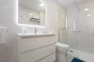 a white bathroom with a toilet and a shower at Reinapart Valencia Beach in Valencia