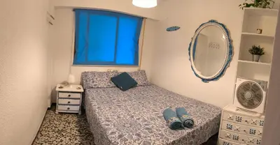 a small bedroom with a bed and a mirror at BLUE DOUBLE PRIVATE ROOM AT FRONT BEACH - HABITACION en la playa piso compartido in Valencia