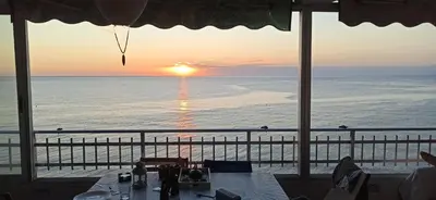 a view of the ocean at sunset from a restaurant at BLUE DOUBLE PRIVATE ROOM AT FRONT BEACH - HABITACION en la playa piso compartido in Valencia