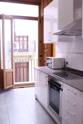 a kitchen with white appliances and a large window at Apartment Plaza de la Merced in Valencia