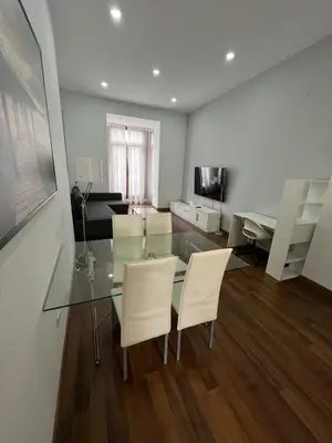 a living room with a glass table and white chairs at Apartment Plaza de la Merced in Valencia