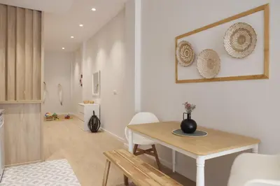 a living room with a wooden table and chairs at FLORIT FLATS - The Maritim Serreria Suites in Valencia