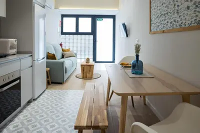 a kitchen and living room with a table and a couch at FLORIT FLATS - The Maritim Serreria Suites in Valencia