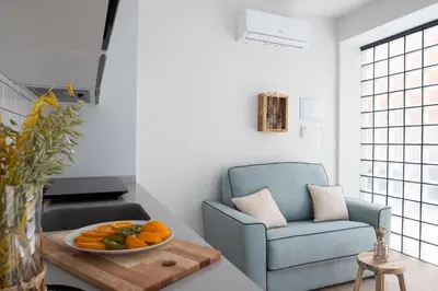 a living room with a blue chair and a bowl of fruit at FLORIT FLATS - The Maritim Serreria Suites in Valencia