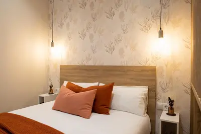 a bedroom with a bed with orange and white pillows at FLORIT FLATS - The Maritim Serreria Suites in Valencia