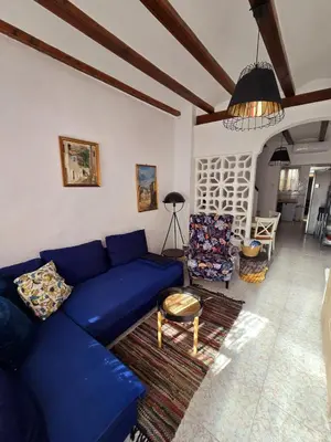 a living room with a blue couch and a table at Holiday House - Casa de Sylvia in Cullera