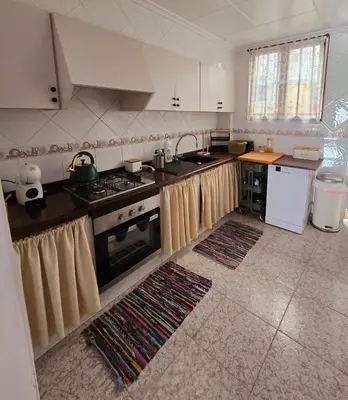 a kitchen with a stove and a sink at Holiday House - Casa de Sylvia in Cullera
