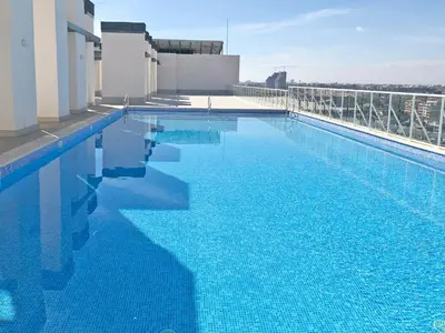 a large blue swimming pool on top of a building at Global Vacacional, Moderno apartamento con terraza y vistas al mar in Canet de Berenguer