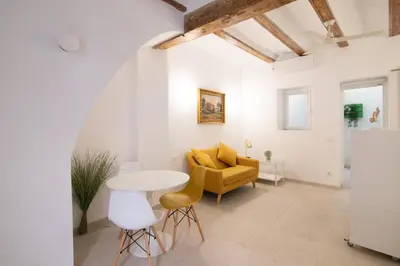 a living room with a yellow couch and a table at Cabanyal old fisherman's house in Valencia