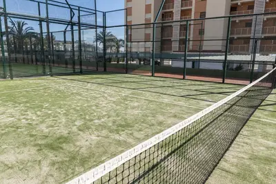 a tennis court with a net in front of a building at Florazar 1, II-A 11-B in Cullera