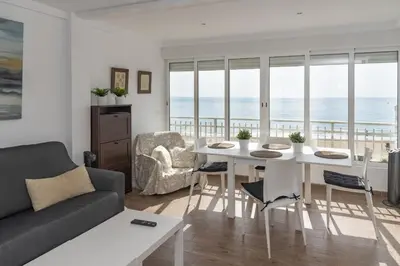 a living room with a table and chairs and the ocean at Florazar 1, II-A 11-B in Cullera