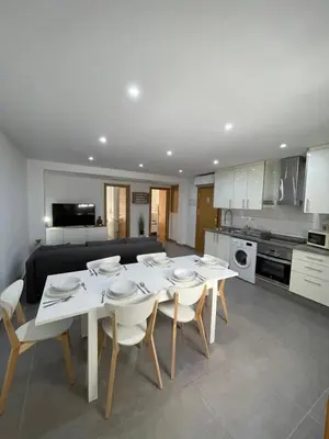 a kitchen and dining room with a white table and chairs at UIM Mediterraneo Libertad 1 Wifi in Puerto de Sagunto