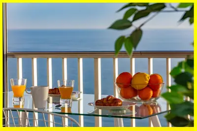 a glass table with a bowl of fruit on a balcony at Cullera Panoramic Sea Views Apartment in Cullera