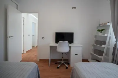 a bedroom with two beds and a desk with a computer at DREAM HOUSE in Burriana