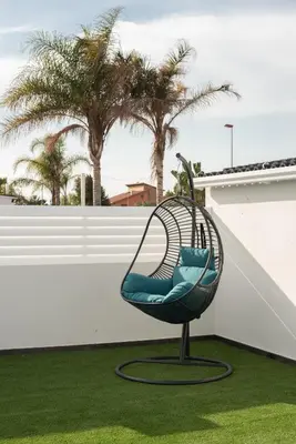 a chair on a slide in a yard with palm trees at DREAM HOUSE in Burriana