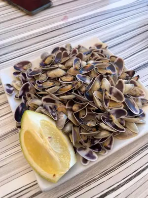 a plate of mussels and a lemon on a table at Florazar 2 Cullera in Cullera
