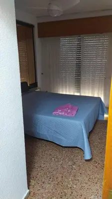 a bedroom with a blue bed with a pink shirt on it at Florazar 2 Cullera in Cullera