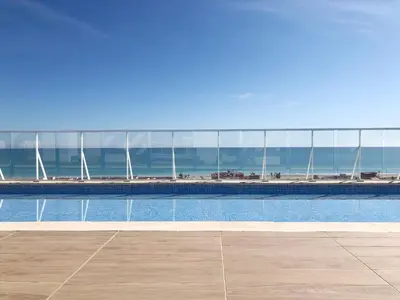 a swimming pool with a view of the ocean at Global Vacacional, Apartamento con vistas al mar, Canet d'en Berenguer in Canet de Berenguer