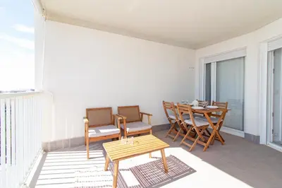 a balcony with a wooden table and chairs on a balcony at Global Vacacional, Apartamento con vistas al mar, Canet d'en Berenguer in Canet de Berenguer