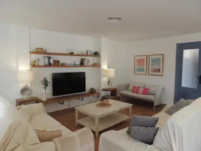 a living room with white furniture and a flat screen tv at ACOGEDOR ADOSADO entre mar y montaña in Cullera