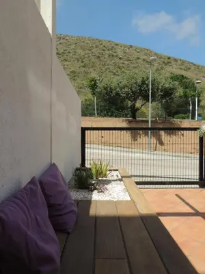 a couch sitting on a patio with a fence at ACOGEDOR ADOSADO entre mar y montaña in Cullera