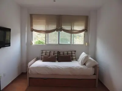 a bed in a room with a window at ACOGEDOR ADOSADO entre mar y montaña in Cullera