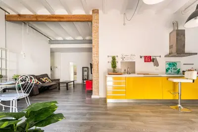 a kitchen and living room with yellow cabinets and a couch at 120 sqm Loft-style Apartment Beach Royal Marina in Valencia