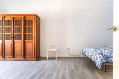 a bedroom with a bed and a wooden cabinet at 120 sqm Loft-style Apartment Beach Royal Marina in Valencia