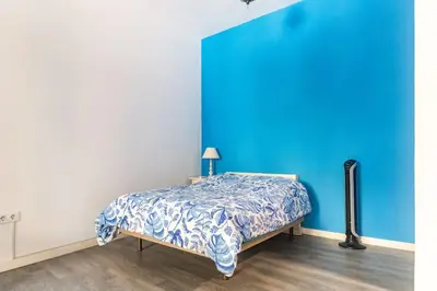 a bedroom with a bed with a blue wall at 120 sqm Loft-style Apartment Beach Royal Marina in Valencia