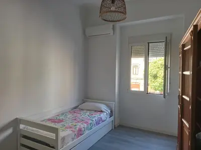 a small bedroom with a bed and a window at 120 sqm Loft-style Apartment Beach Royal Marina in Valencia