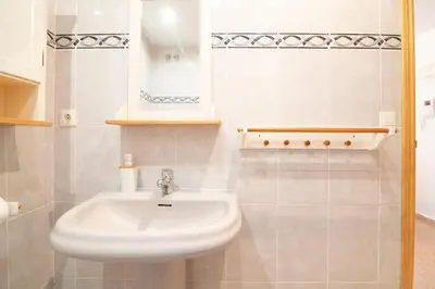 a bathroom with a white sink and a mirror at Global Vacacional, Practico apartamento con piscina en Residencial Brezo Canet in Canet de Berenguer