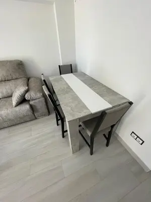 a dining table and a couch in a living room at Precioso apartamento de lujo en cullera in Cullera