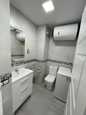 a white bathroom with a toilet and a sink at Precioso apartamento de lujo en cullera in Cullera
