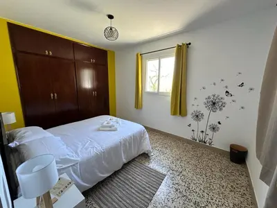 a bedroom with a white bed and a window at Casa Rural Matilde in Caudiel