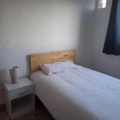 a bedroom with a white bed and a night stand at Casa Rural Matilde in Caudiel