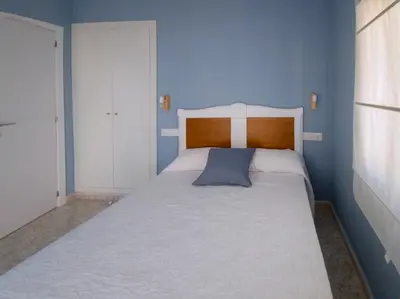 a bedroom with a large bed with a blue wall at CHALET VILLA Los HIPOCAMPOS in Cullera