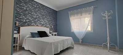 a bedroom with a bed and a blue wall at CHALET VILLA Los HIPOCAMPOS in Cullera