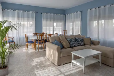 a living room with a couch and a table at CHALET VILLA Los HIPOCAMPOS in Cullera