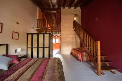 a bedroom with a bed and a staircase in the background at Casa Lucía in Requena