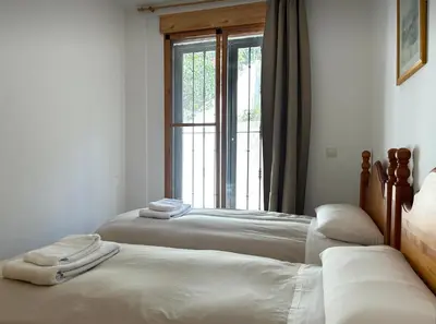 two beds in a room with a window at Apartamentos La Muela - Chulilla in Chulilla