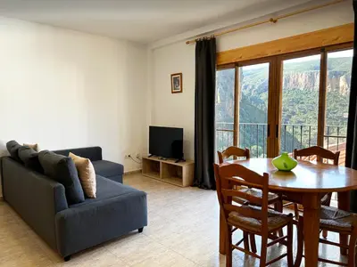 a living room with a table and a couch and a table and chairs at Apartamentos La Muela - Chulilla in Chulilla