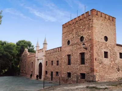 a large red brick building with a tower at MASÍA de SAN JUAN CASA NÚMERO 15 en Castillo con piscina, Aire Acondicionado y terraza privada in Segorbe