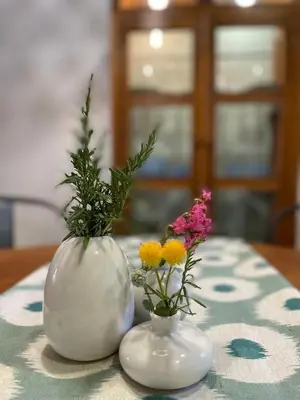 two white vases with flowers in them on a table at MASÍA de SAN JUAN CASA NÚMERO 15 en Castillo con piscina, Aire Acondicionado y terraza privada in Segorbe