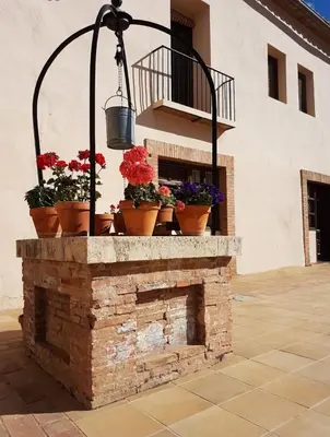 a brick fireplace with potted plants on top of it at MASÍA de SAN JUAN CASA NÚMERO 15 en Castillo con piscina, Aire Acondicionado y terraza privada in Segorbe
