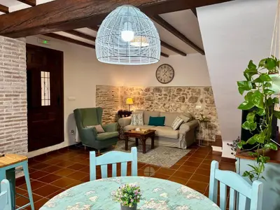 a living room with a couch and a table and chairs at MASÍA de SAN JUAN CASA NÚMERO 1 en Castillo con piscina y Aire Acondicionado in Segorbe