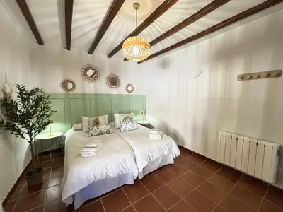 a bedroom with a bed and a chandelier at MASÍA de SAN JUAN CASA NÚMERO 1 en Castillo con piscina y Aire Acondicionado in Segorbe